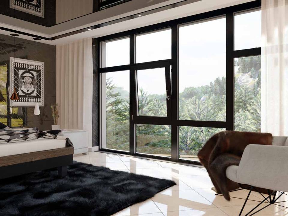 Grandes fenêtres aluminium noires dans une chambre ouverte sur la forêt